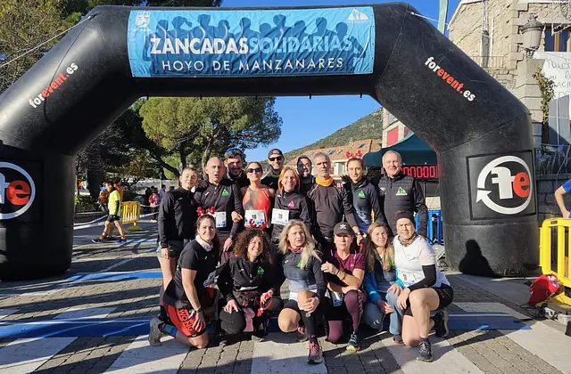A group of runners under the Zancadas Solidarias arch in 2025
